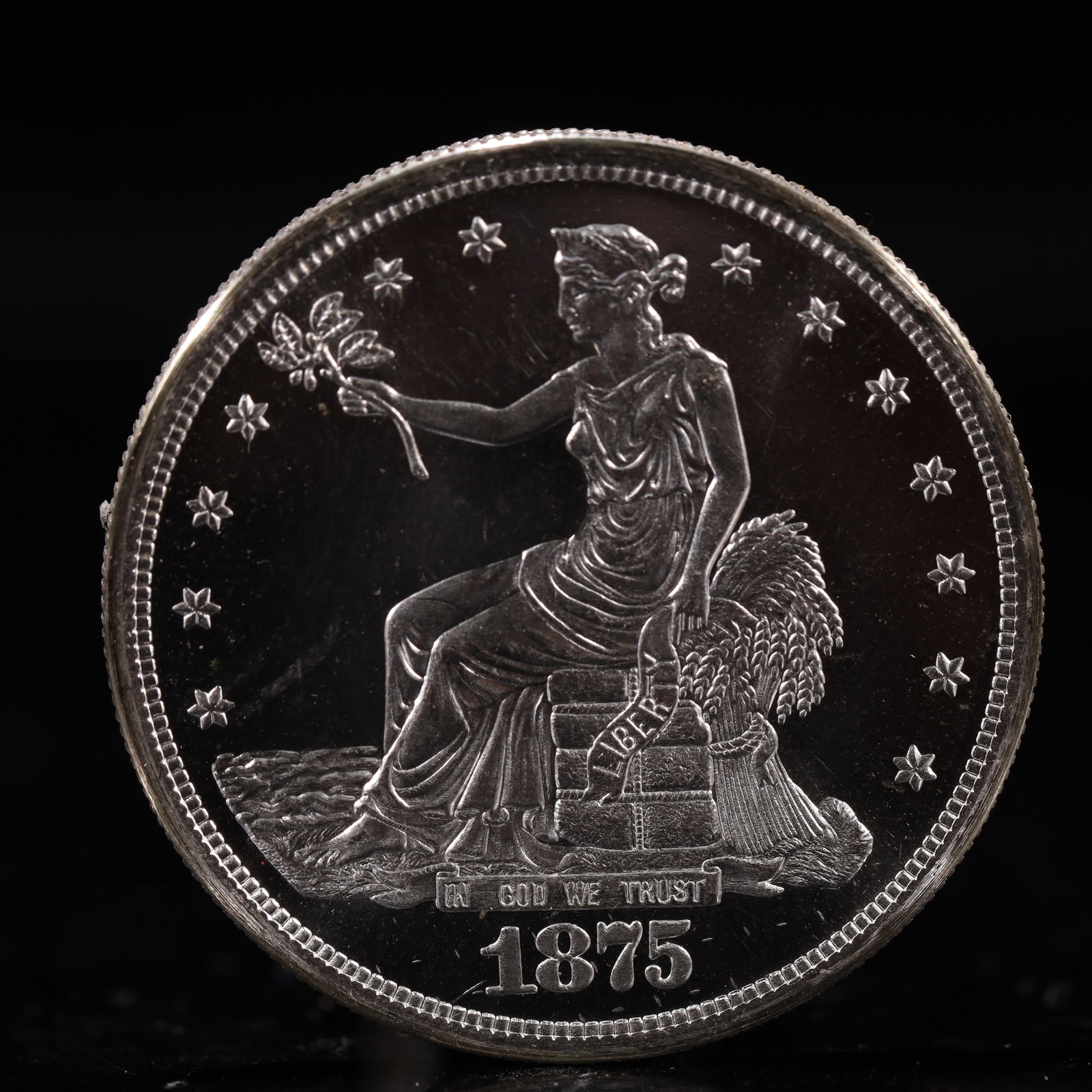USA Trade Dollar 1875 Coin: American coin. Obverse: Liberty seated on a pedestal facing the sea to the left holding olive branches surrounded by 13 stars. IN GOD WE TRUST / LIBERTY / 1875. Reverse: An eagle holding branches with