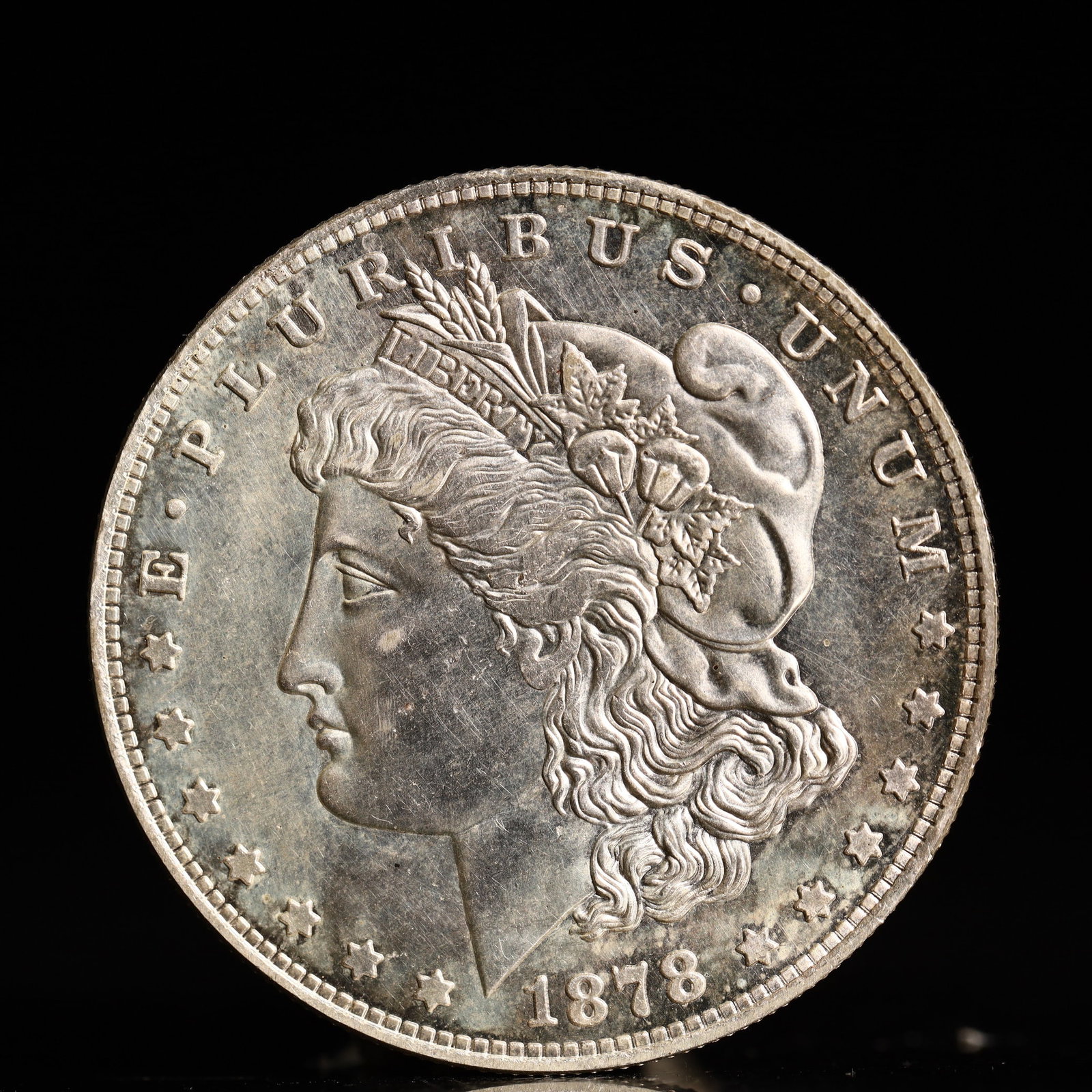 USA Morgan Dollar 1878 Coin: Obv: profile bust with date below and E PLURIBUS UNUM legend and stars around. Rev: eagle with In God we trust above within wreath with UNITED STATES OF AMERICA ONE DOLLAR legend. IN GOD WE TRUST /