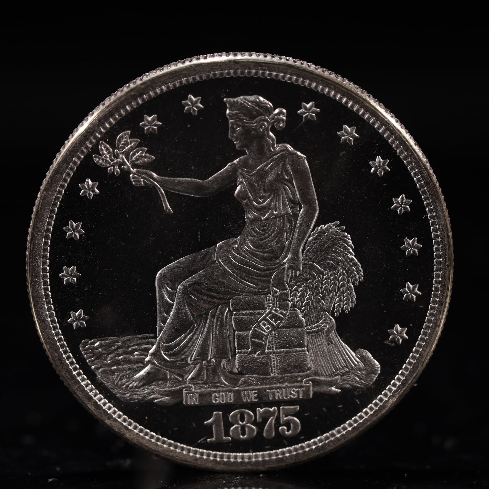 USA Trade Dollar 1875 Coin: American coin. Obverse: Liberty seated on a pedestal facing the sea to the left holding olive branches surrounded by 13 stars. IN GOD WE TRUST / LIBERTY / 1875. Reverse: An eagle holding branches with