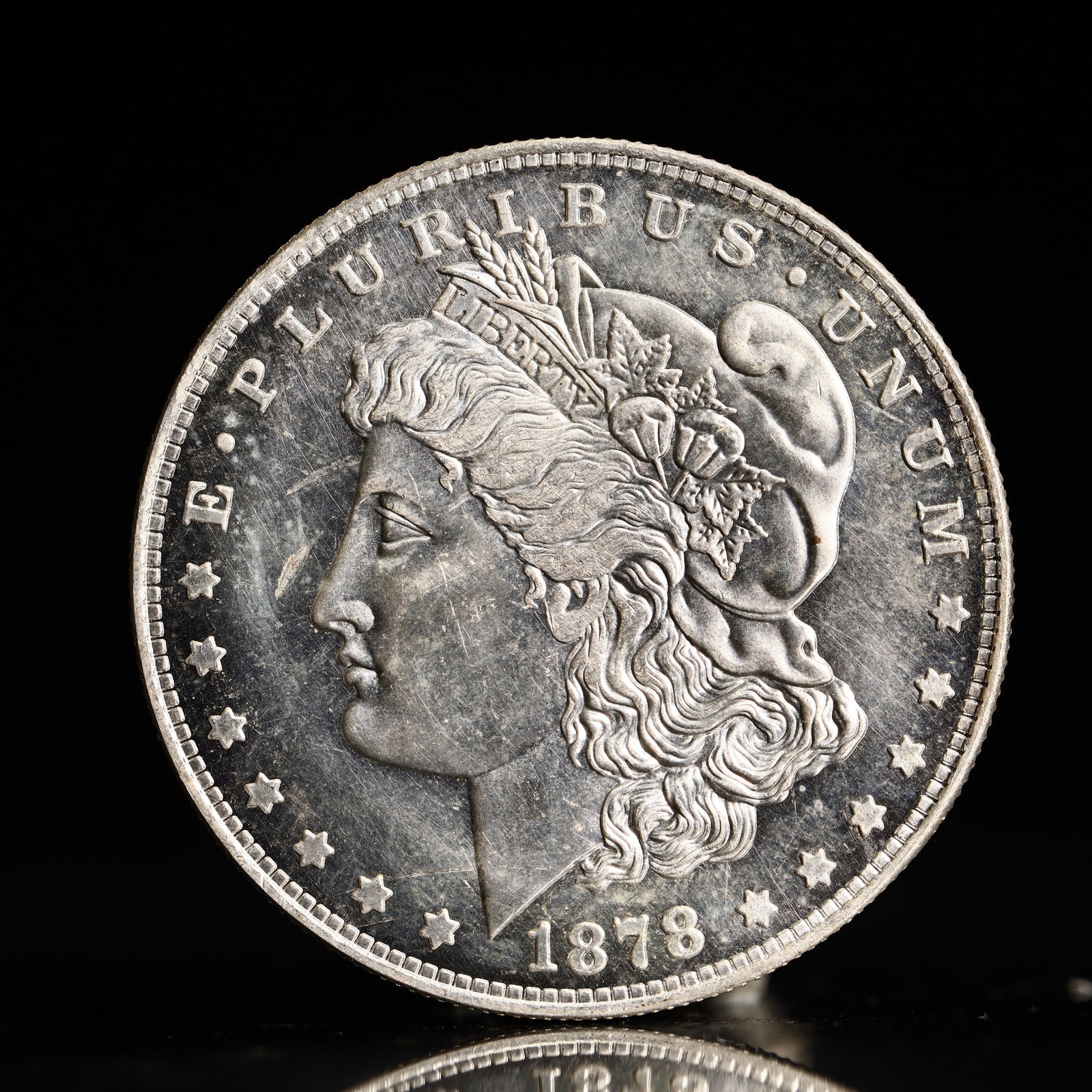USA Morgan Dollar 1878 Coin: Obv: profile bust with date below and E PLURIBUS UNUM legend and stars around. Rev: eagle with In God we trust above within wreath with UNITED STATES OF AMERICA ONE DOLLAR legend. IN GOD WE TRUST / LI