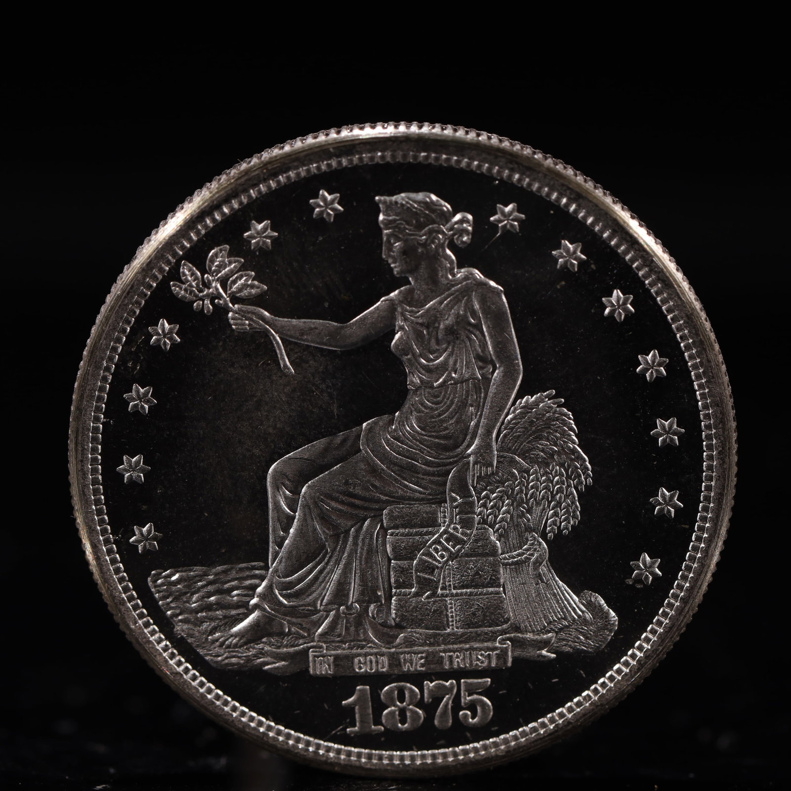 USA Trade Dollar 1875 Coin: American coin. Obverse: Liberty seated on a pedestal facing the sea to the left holding olive branches surrounded by 13 stars. IN GOD WE TRUST / LIBERTY / 1875. Reverse: An eagle holding branches with