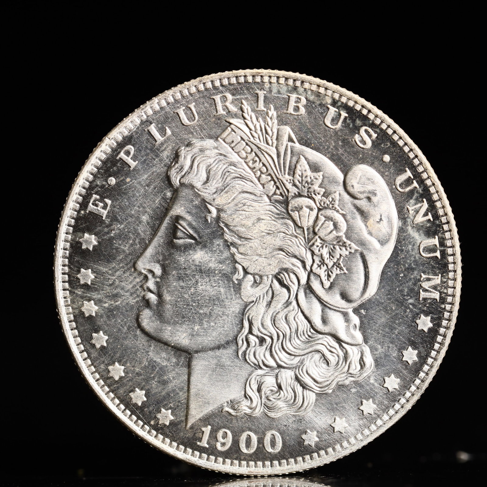 USA Morgan Dollar 1900 Coin: Obv: profile bust with date below and E PLURIBUS UNUM legend and stars around. Rev: eagle with In God we trust above within wreath with UNITED STATES OF AMERICA ONE DOLLAR legend. IN GOD WE TRUST /