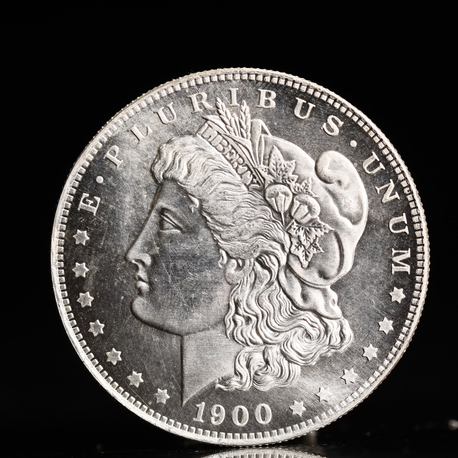 USA Morgan Dollar 1900 Coin: Obv: profile bust with date below and E PLURIBUS UNUM legend and stars around. Rev: eagle with In God we trust above within wreath with UNITED STATES OF AMERICA ONE DOLLAR legend. IN GOD WE TRUST / LI