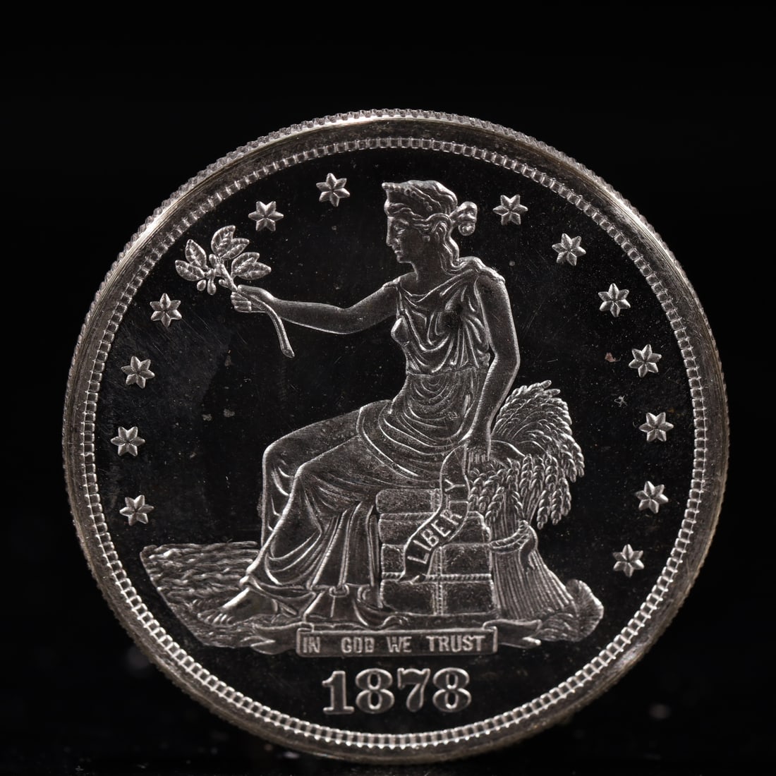 USA Trade Dollar 1878 Coin: American coin. Obverse: Liberty seated on a pedestal facing the sea to the left holding olive branches surrounded by 13 stars. IN GOD WE TRUST / LIBERTY / 1878. Reverse: An eagle holding branches with
