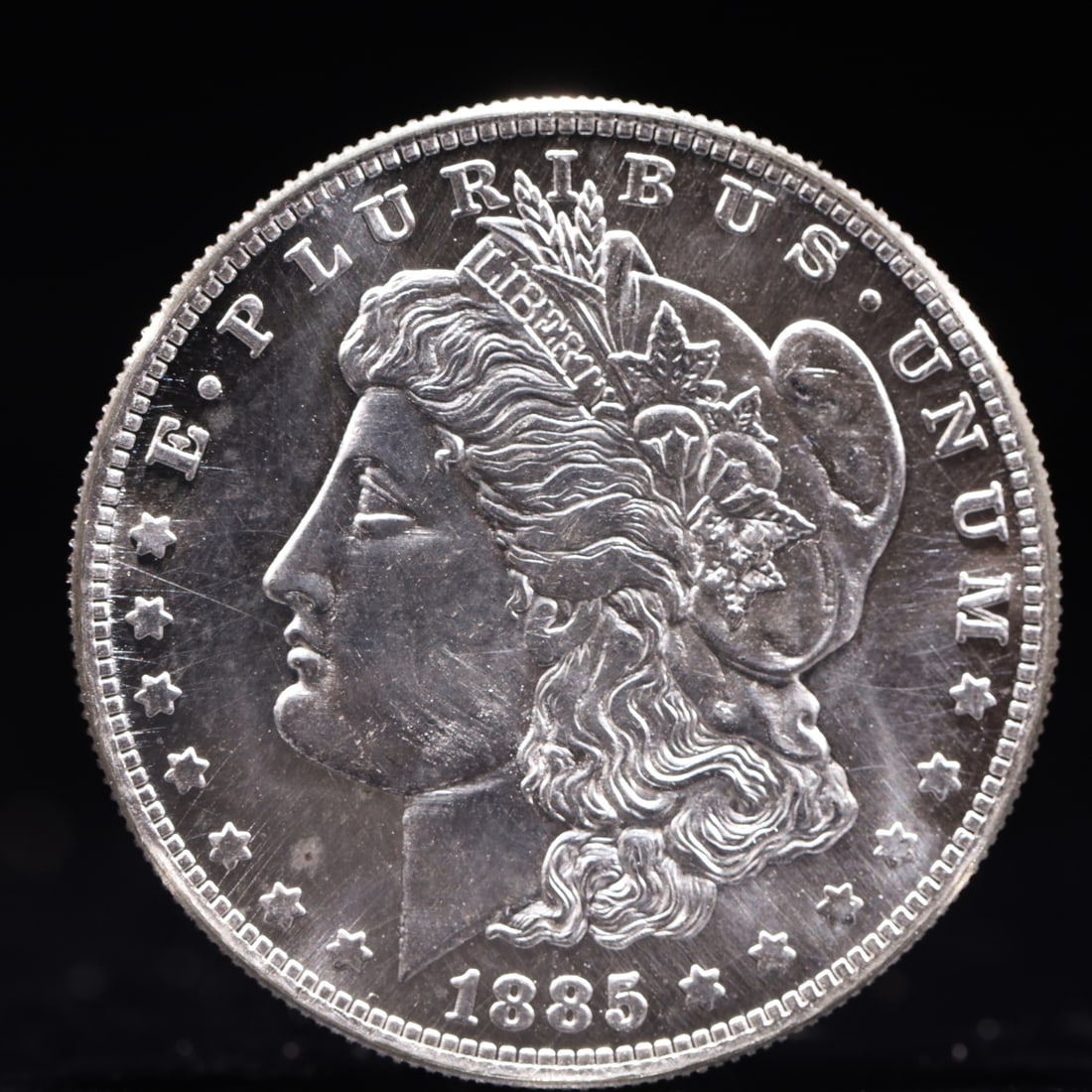 USA Morgan Dollar 1885 Coin: Obv: profile bust with date below and E PLURIBUS UNUM legend and stars around. Rev: eagle with In God we trust above within wreath with UNITED STATES OF AMERICA ONE DOLLAR legend. IN GOD WE TRUST / LI