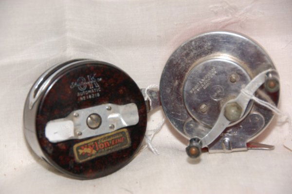 Shakespeare OK Automatic No. 1821B tortoise shell s: Shakespeare OK Automatic No. 1821B tortoise shell stlye reel (w/ "Nylon Line" sticker still attached), and a Wright & McGill Fre-Line in silver metal on one side and red on the other.