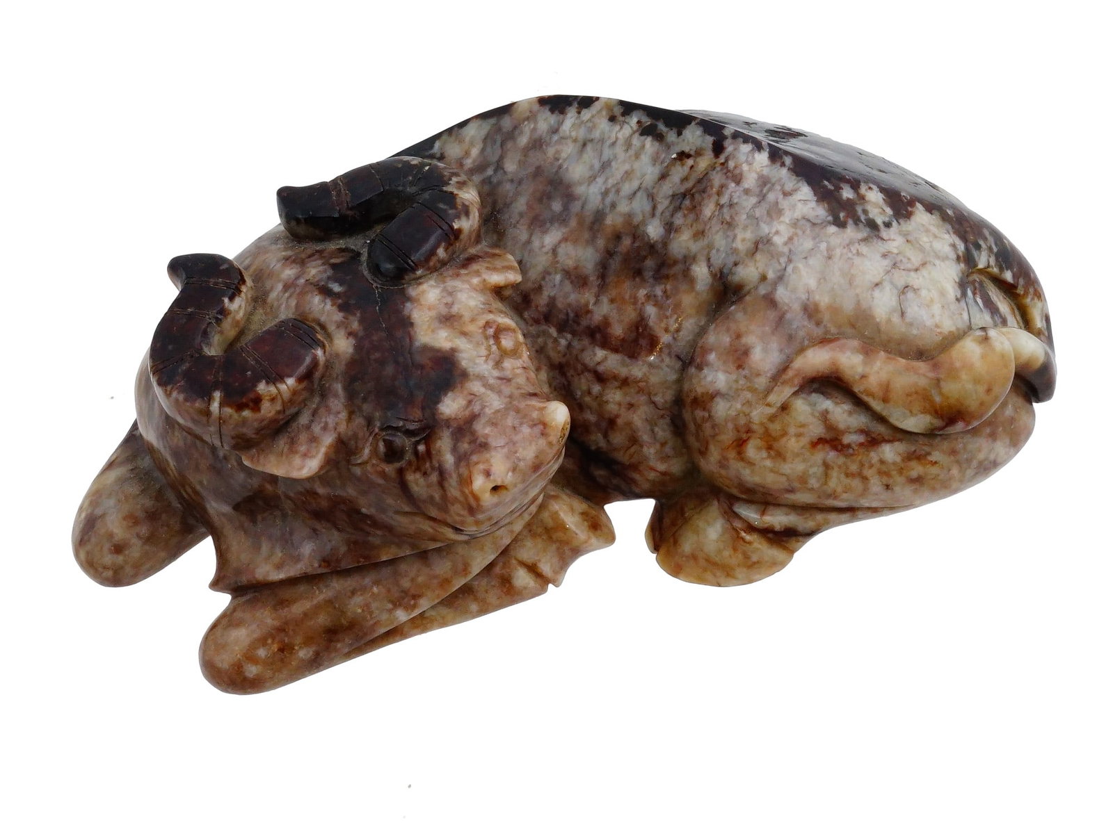 CHINESE CARVED HARDSTONE WATER BUFFALO: A Chinese carved hardstone figure of a recumbent water buffalo. The heavily mottled brown, grey, and white stone is carved in a traditional posture with legs tucked beneath the body, curved horns, and