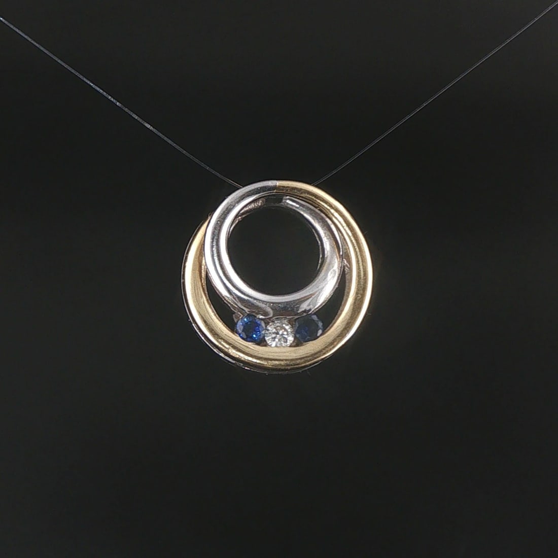 14k Yellow and White Gold Sapphire and Diamond Circle Slide Pendant: Condition: Excellent Condition, Professionally Cleaned Metal: 14k Gold (Marked, and Professionally Tested) Weight: 4.4g Gemstone: Two Round Cut Blue Sapphires Diamonds: 0.05ct Round Cut Natural Diamon