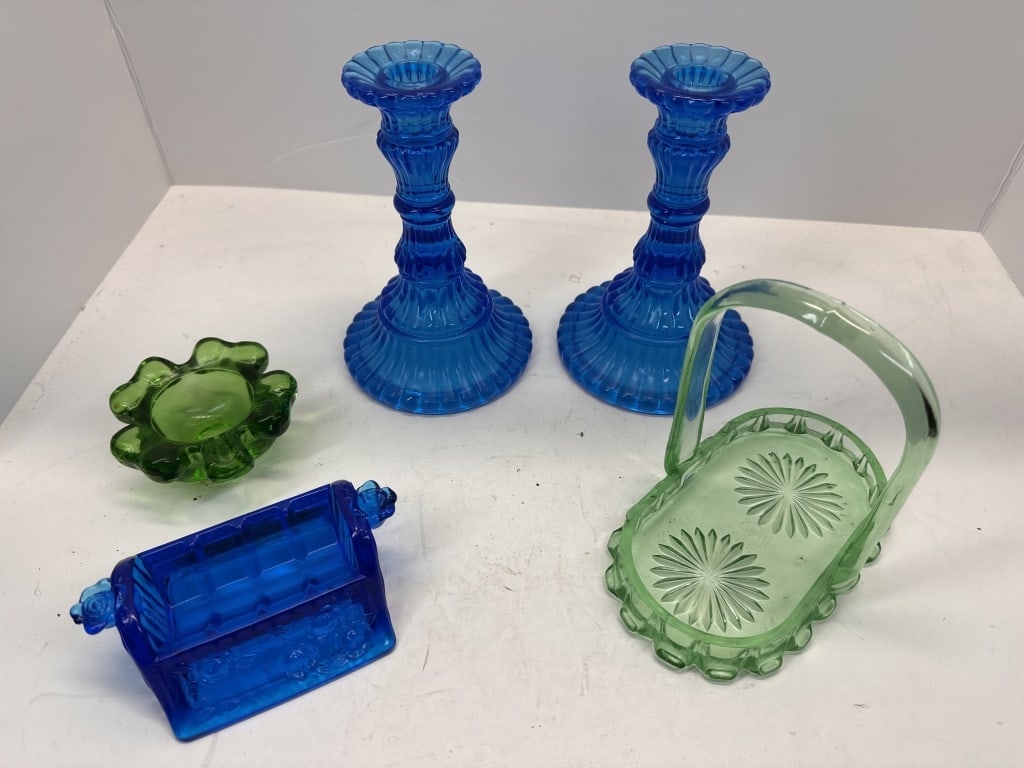 BLUE AND GREEN GLASSWARE: TWO BLUE GLASS CANDLE HOLDERS, ONE GREEN GLASS SHAMROCK DISH, ONE VINTAGE BLUE GLASS LUTTED'S COUGH DROP BOX WITHOUT LID, ONE GREEN GLASS BASKET