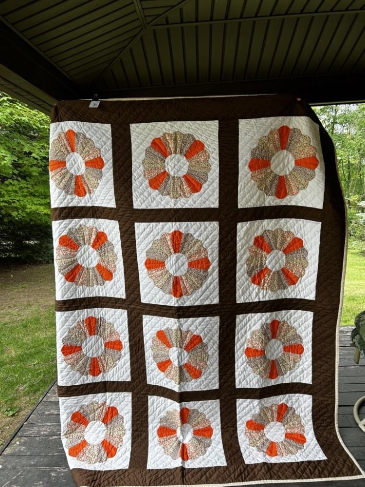 ORANGE FLORAL PATTERNED QUILT: BROWN AND WHITE QUILT BLANKET WITH ORANGE FLORAL PATTERNED FLOWER SHAPES