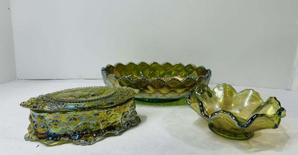 American Green Iridescent Carnival Glass Tableware Items: This group consists of three pieces of American green carnival glass featuring a Helios iridescent finish with highlights of gold, blue, and purple. The first item is a lidded oval trinket box, attrib
