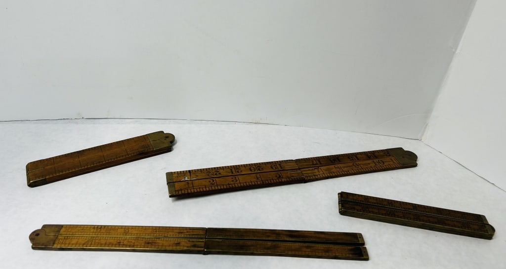 Vintage Boxwood and Brass Folding Rules including Rabone and Lufkin Models: A collection of vintage folding rules constructed from boxwood with brass hinges and end tips. The assembly includes various models featuring different measurement scales. One rule displays markings f
