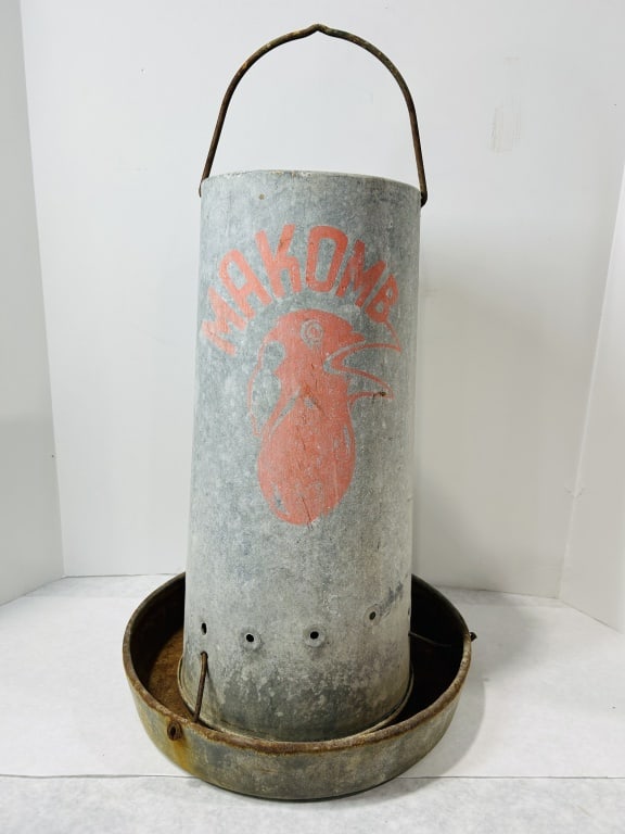 Vintage Makomb Galvanized Steel Poultry Feeder: This is a mid-century poultry feeder manufactured by the Makomb Steel Products Co. of Macomb, Illinois. The unit is constructed from galvanized steel and features a tall cylindrical hopper mounted ove
