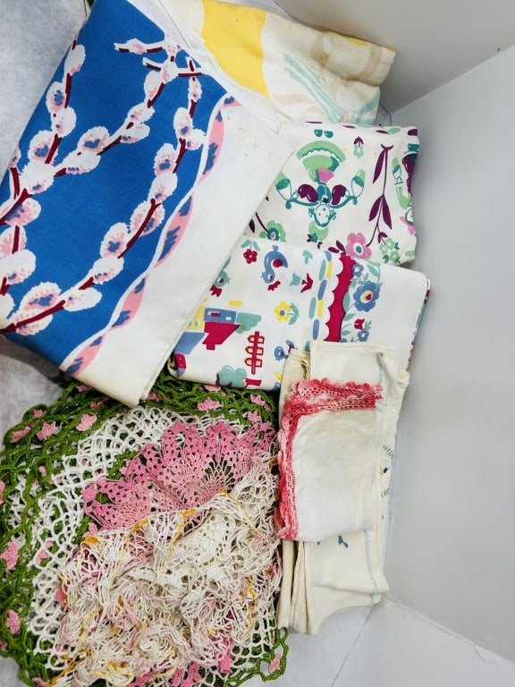 Vintage Mid-20th Century Printed Cotton Tablecloths and Crocheted Linens: This collection consists of multiple vintage household textiles and table linens dating from the mid-20th century. The lot features several printed cotton textiles, including a large tablecloth with a