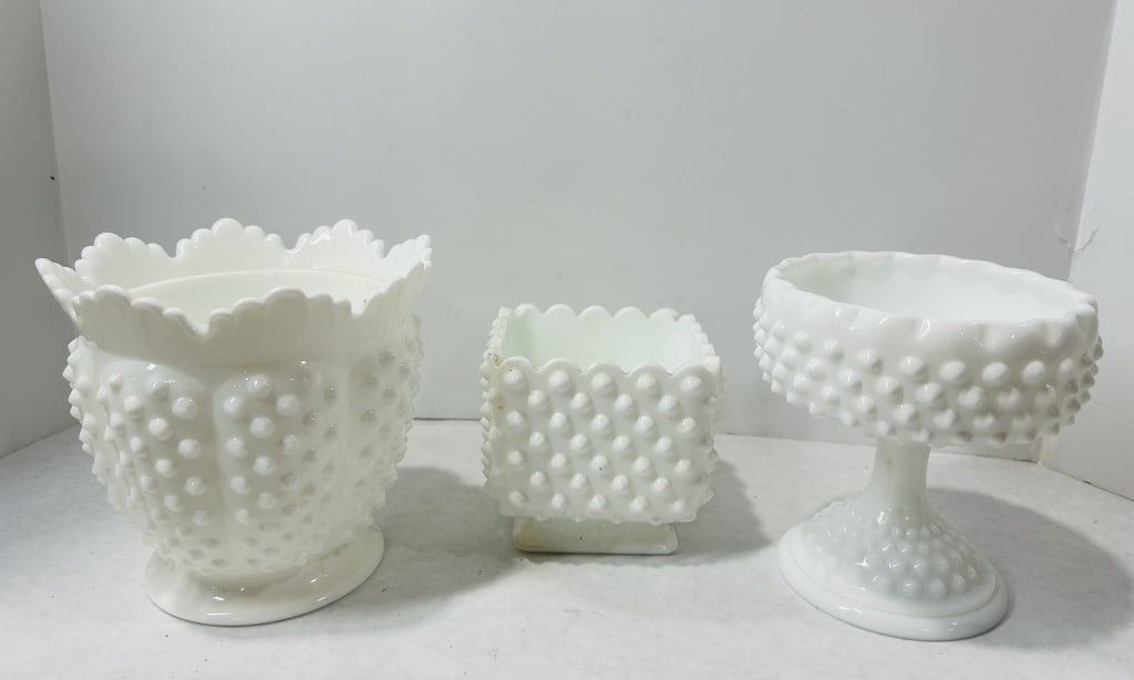 A Trio of Fenton Hobnail Milk Glass Decorative Items: A collection of three opaque white milk glass items produced by the Fenton Art Glass Company featuring the hobnail pattern. The group includes a large footed bowl with a crimped and ruffled rim, a squ