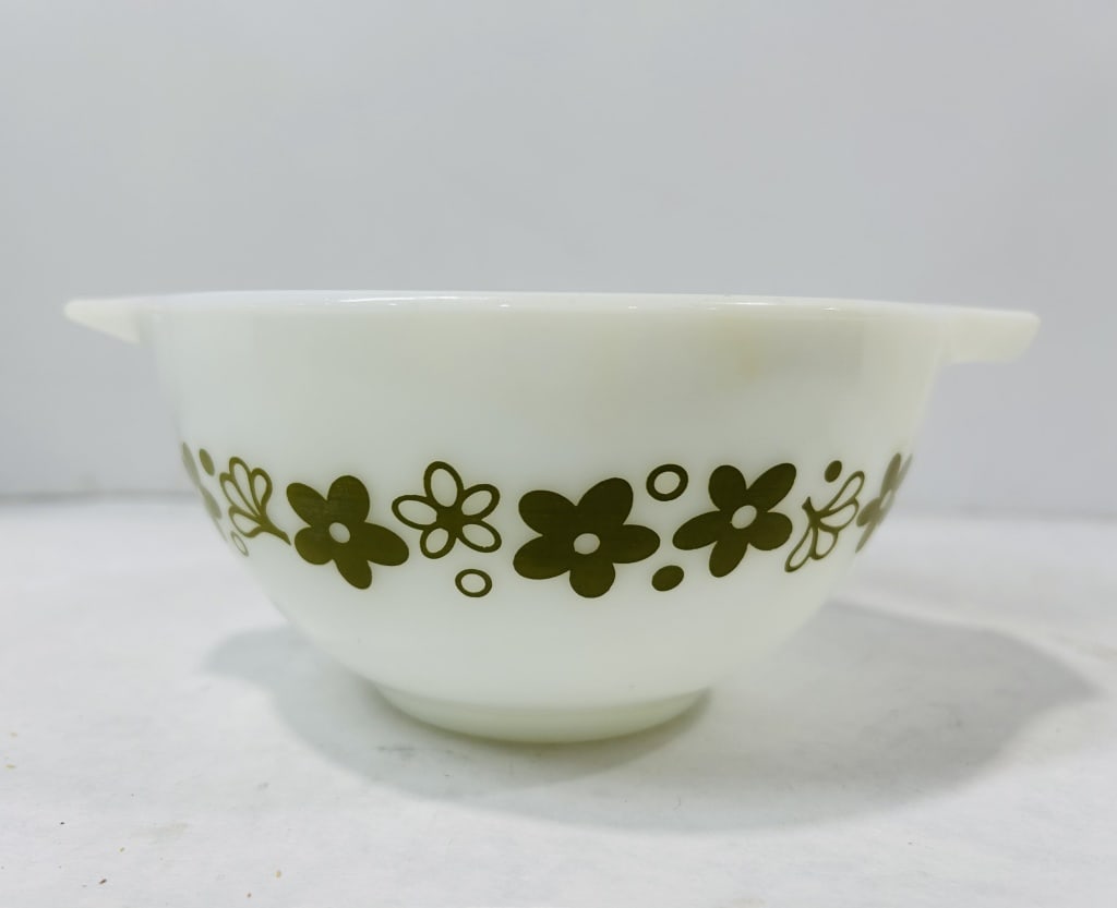 Milk Glass Cinderella Mixing Bowl in the Spring Blossom Green Pattern: This white milk glass Cinderella-style mixing bowl is designed with two integrated pouring spouts that function as handles. The exterior body features a horizontal band of olive green stylized flowers