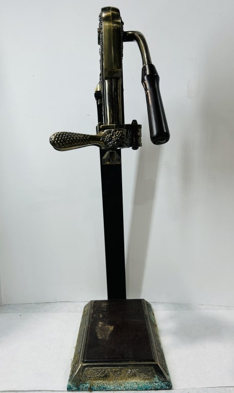 Vintner Reserve Ornate Brass-Finished Tabletop Wine Bottle Opener on Stand: A decorative tabletop wine bottle corkscrew, Vintner model, attributed to Rogar. The device is constructed from brass-toned metal and features a dark turned-wood handle. The main body is heavily decor