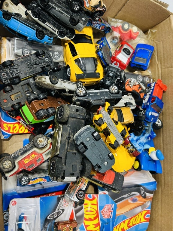 Hot Wheels and Other Die-Cast Toy Vehicles: This lot consists of a diverse collection of die-cast toy vehicles from various manufacturers, with a significant representation of Hot Wheels models. The assortment includes both loose items and vehi