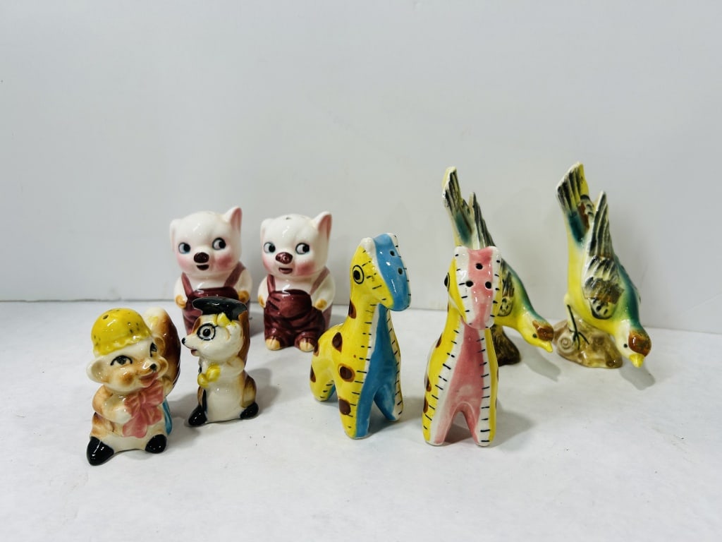 Mid-Century Glazed Ceramic Animal Salt and Pepper Shakers: A collection of mid-century style salt and pepper shakers crafted from glazed and hand-painted ceramic. The assortment includes multiple anthropomorphic figurines featuring pigs wearing overalls, squi