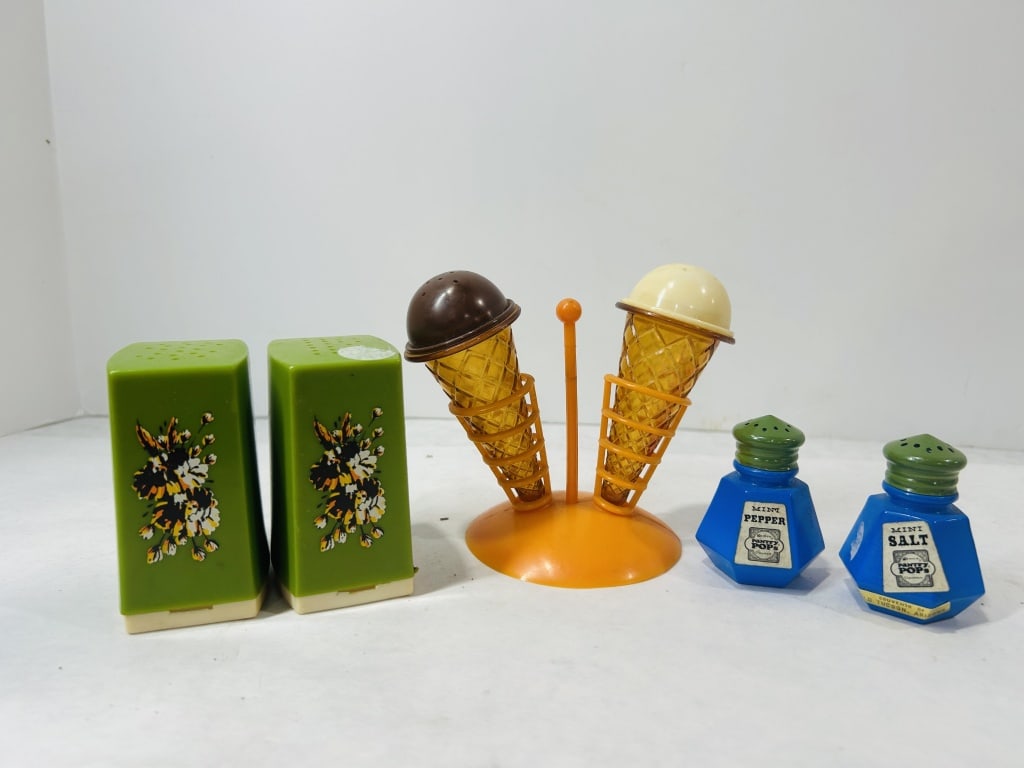 Vintage Novelty Plastic Salt and Pepper Shakers: An assortment of mid-century novelty salt and pepper shakers. The lot includes a set of Gemco Pantry Pops shakers featuring blue faceted plastic bodies and green screw-on lids. These shakers retain th
