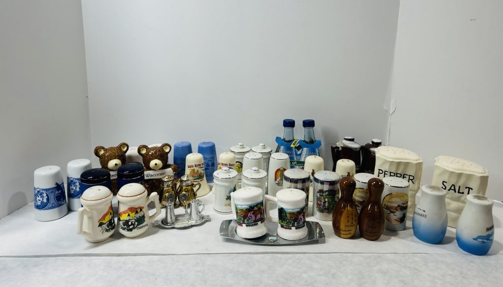 Vintage Souvenir and Novelty Salt and Pepper Shakers: An assortment of souvenir and novelty salt and pepper shakers in various materials including ceramic, wood, glass, and metal. The collection features numerous travel and commemorative themes. Visible 