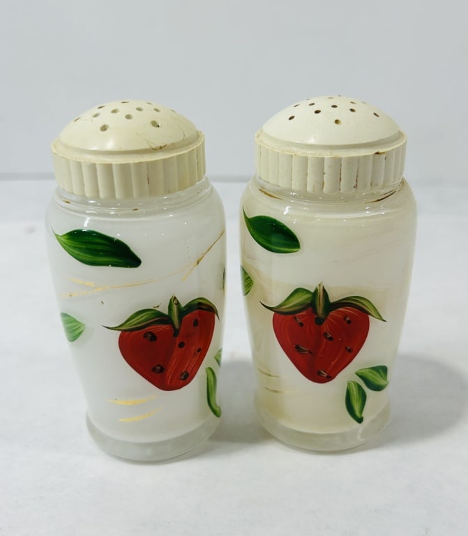 Vintage Milk Glass Salt and Pepper Shakers: A group of vintage milk glass salt and pepper shakers comprising two distinct pairs. One pair features tapered white glass bodies decorated with hand-painted strawberry and green leaf motifs, accented