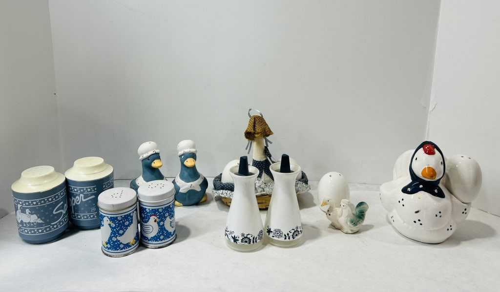Vintage Country-Style Kitchenware and Poultry Motif Shakers: A collection of vintage kitchenware and decorative items characterized by poultry motifs including ducks, chickens, and roosters. The group includes blue plastic dispensers labeled Salt and Pepper, wi