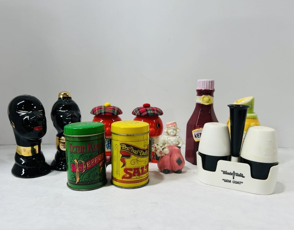 Vintage Ceramic, Tin, and Plastic Salt and Pepper Shakers and Condiment Sets: An assortment of mid-century and vintage salt and pepper shakers and condiment accessories. The collection includes a pair of stylized black ceramic bust shakers with gold-toned neckbands and red lips