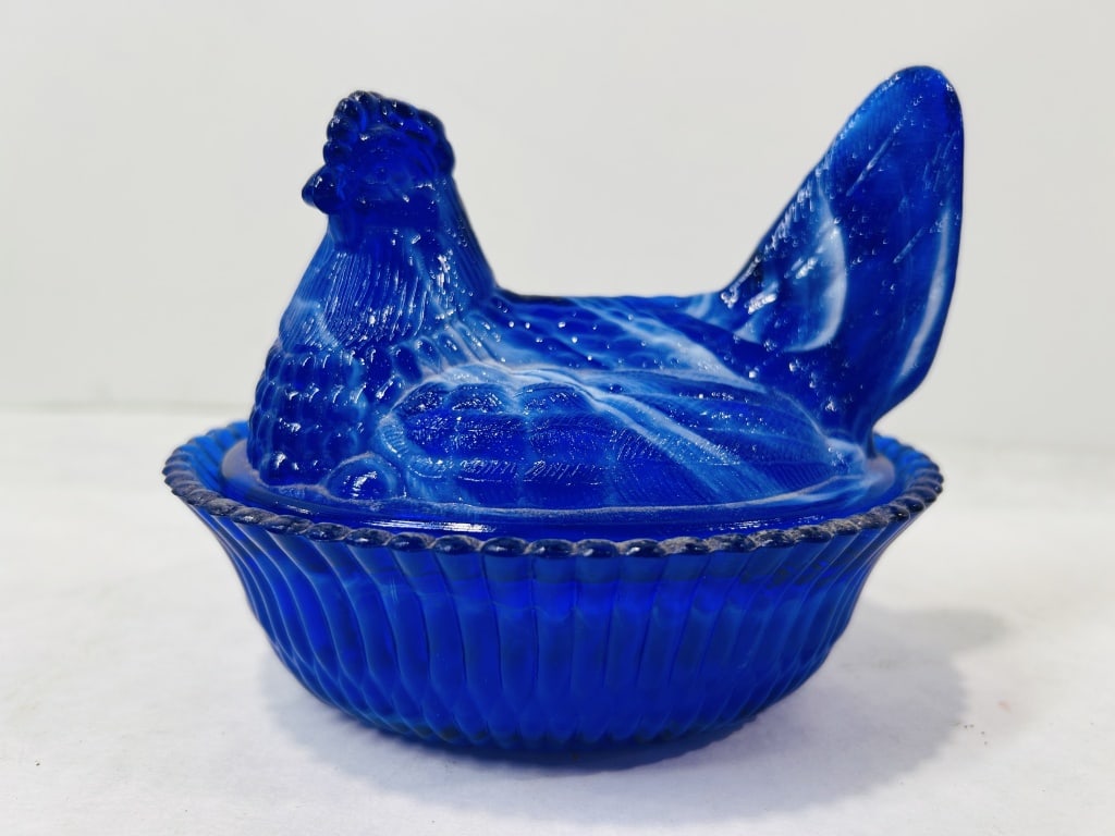 Boyd Cobalt Blue Slag Glass Hen on Nest Covered Dish: This two-piece pressed glass covered dish is produced by Boyd's Crystal Art Glass. The item is crafted from cobalt blue slag glass, characterized by marbleized white swirls throughout the translucent 