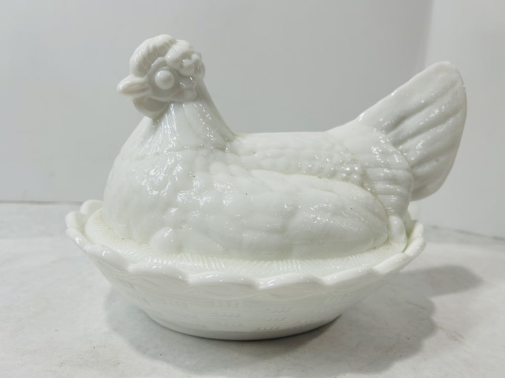 Fenton White Milk Glass Hen On Nest Covered Dish: A Fenton Art Glass Company white milk glass hen-on-nest covered dish. The two-piece set features a figural lid in the form of a hen with detailed molded feathers, a comb, and a beak. The lid sits upon
