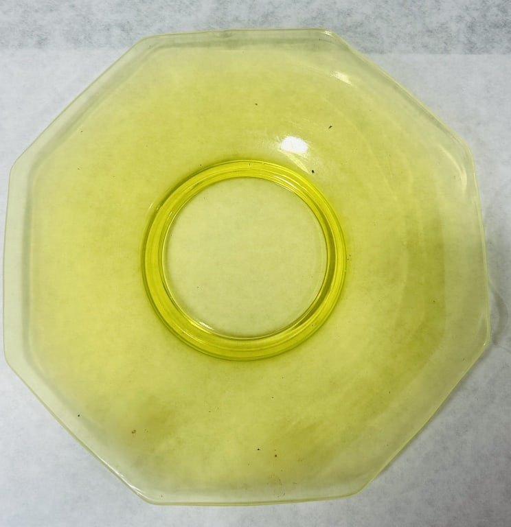 Two Vintage Yellow Uranium Glass Plates: This lot consists of two pieces of vintage yellow pressed glass containing uranium oxide, commonly known as Vaseline glass. The first item is a shallow octagonal plate with a smooth surface and a mold