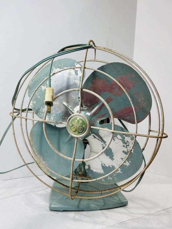 General Electric Oscillating Metal Table Fan: This mid-century General Electric table fan features a streamlined seafoam green finish and a cast metal construction. The unit is designed with a torpedo-style motor housing and a four-blade metal fa