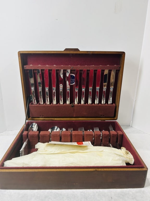 A Collection of Oneida Twin Star Pattern Stainless Steel Flatware in Wooden Chest: A collection of Oneida Twin Star pattern stainless steel flatware, a mid-century modern design originally distributed through General Mills and the Betty Crocker coupon program. The flatware is constr
