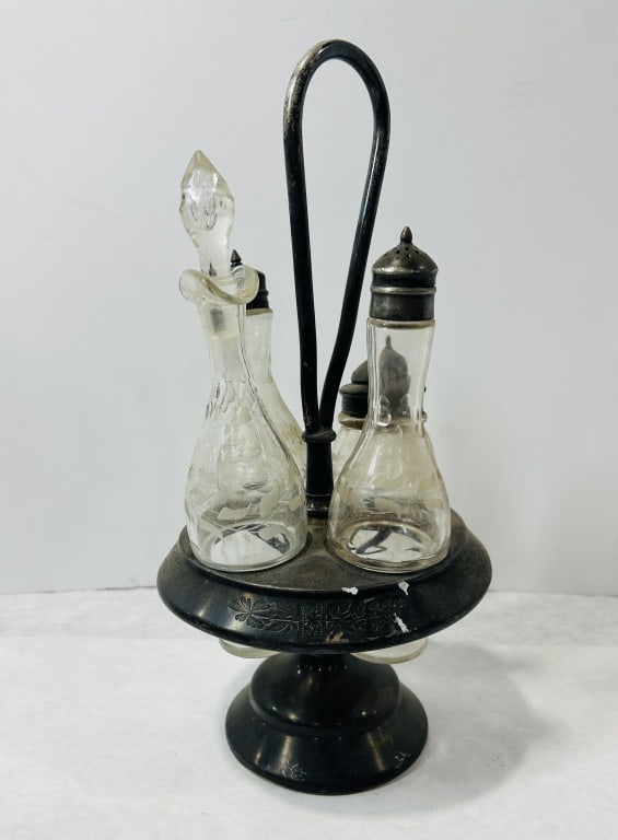 Victorian Silver-Plated Revolving Condiment Cruet Set with Etched Glass Bottles: A Victorian style revolving condiment cruet set featuring a silver-plated pedestal stand and an assortment of matching etched glass bottles. The stand is constructed with a circular revolving rack sup