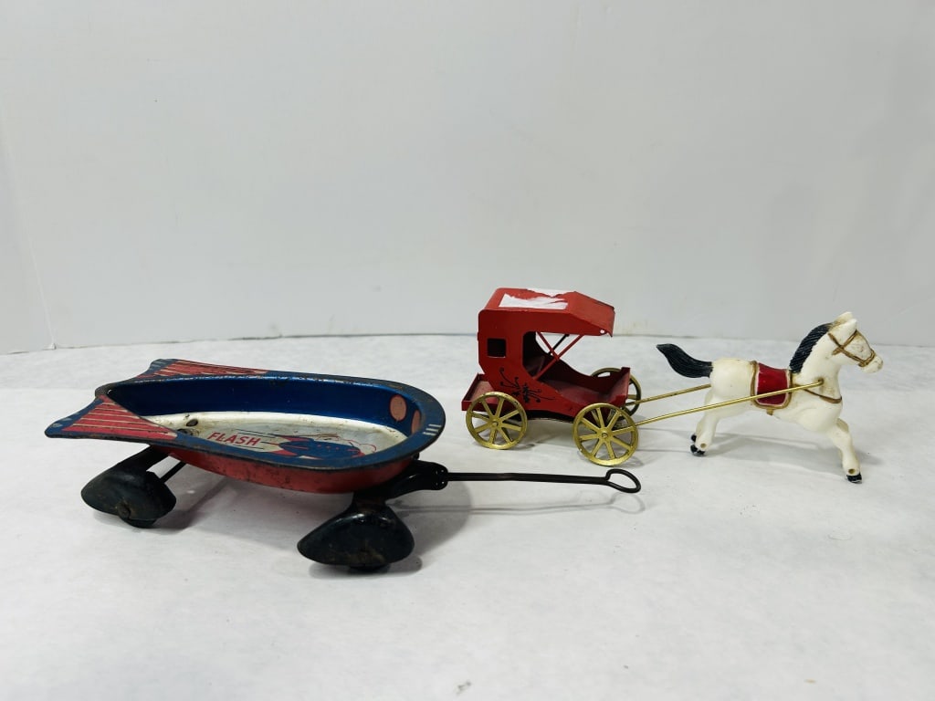 Two Vintage Toy Vehicles including a Flash Strat-O-Wagon and a Horse-Drawn Carriage: A lot consisting of two vintage toy vehicles. The first is a Flash Strat-O-Wagon, a pressed steel pull toy with a streamlined design. The body features blue-painted side rails and red-striped rear fin