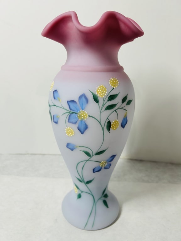 Fenton Hand Painted Periwinkle Blue Burmese Glass Vase Signed by Vicki Kelley: This Fenton Art Glass Company vase is a limited edition piece hand-signed by decorator Vicki Kelley. The vase is fashioned from satin-finished glass, exhibiting a color transition from a pale blue at 