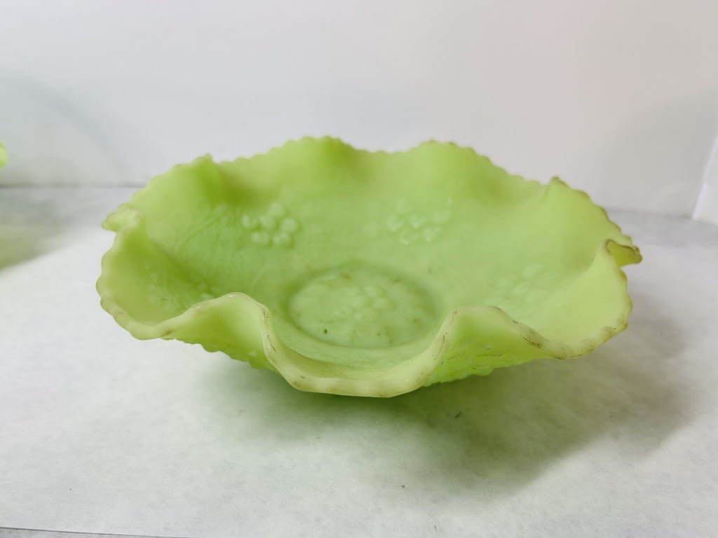 Fenton Lime Green Satin Custard Glass Cherry Chain Ruffled Bowl: This Fenton Art Glass bowl is crafted from opaque lime-green custard glass with a matte satin finish. The glass contains uranium, which causes the piece to fluoresce bright green under ultraviolet lig