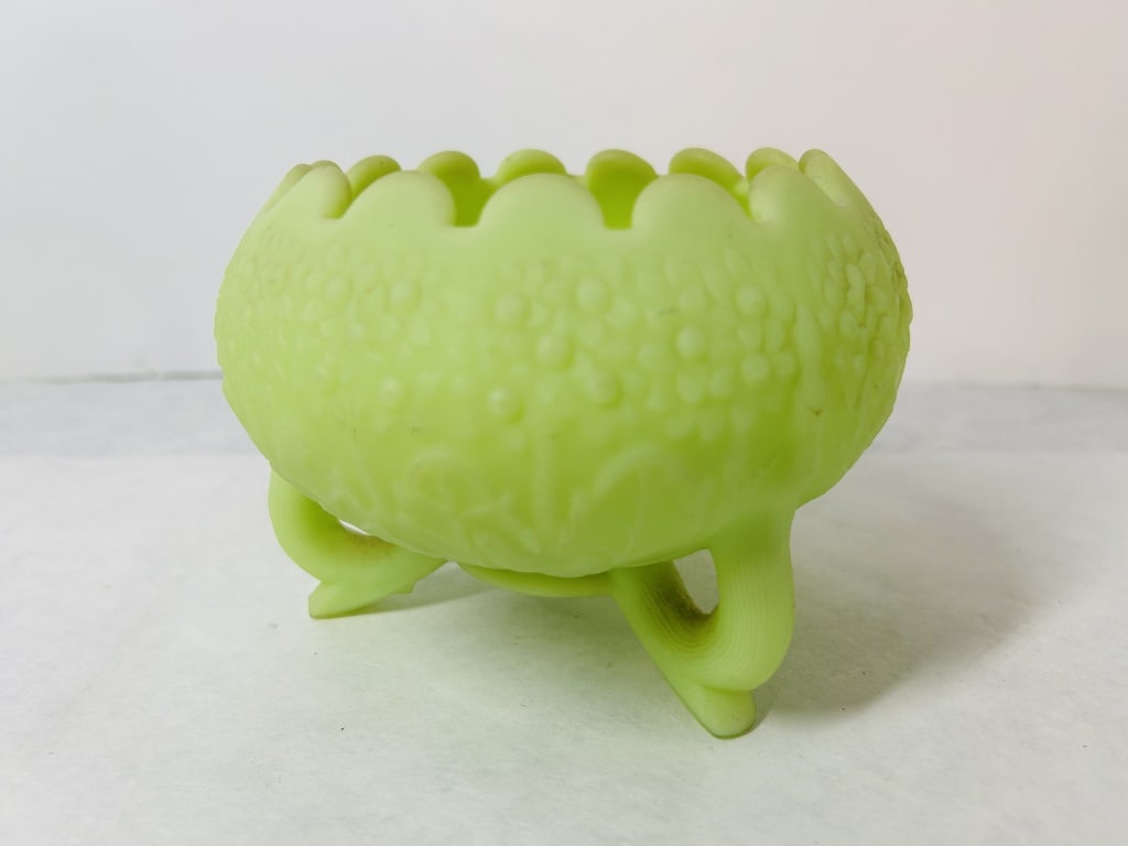 Fenton Custard Uranium Glass Three-Footed Bowl in Forget-Me-Not Pattern: This is a Fenton Art Glass Company bowl in the Forget-Me-Not pattern. The item is crafted from lime green custard glass with a satin finish. It features uranium oxide in its composition, which causes 