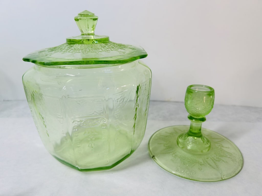 A Group of Green Uranium Depression Glass Tableware including a Lidded Biscuit Jar: This lot features an assortment of translucent light green depression glass items, all confirmed as uranium glass by their bright green fluorescence under ultraviolet light. The collection includes a 