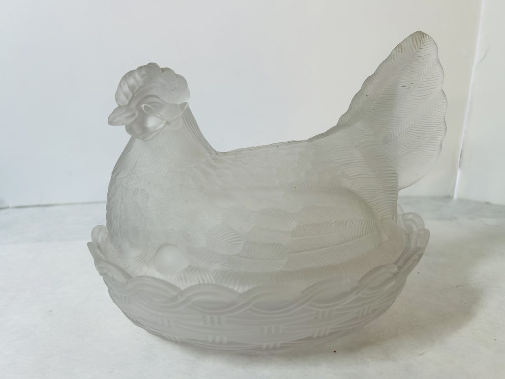 Vintage Frosted Satin Glass Hen on Nest Covered Dish: This is a two-piece figural covered dish crafted from colorless glass with an acid-etched frosted satin finish. The lid is molded in the form of a nesting hen, featuring detailed feathering and an upr