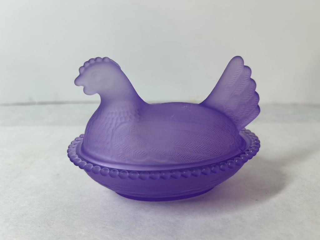 Purple Satin Glass Hen on Nest Covered Dish: This is a two-piece decorative covered dish in the classic hen on nest form, crafted from purple glass with a frosted satin finish.. The set consists of a molded lid in the shape of a nesting hen and 