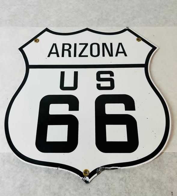 Arizona US Route 66 Die-Cut Metal Shield Sign: A shield-shaped highway route sign commemorating Arizona US Route 66. The sign is constructed of die-cut metal with a white and black finish, resembling porcelain enamel on steel. The design features 