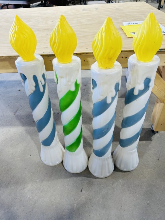 A Group of Vintage Blow-Mold Holiday Candle Lawn Decorations attributed to Empire: This lot features a group of large-scale blow-molded plastic holiday decorations designed as lighted candles. Each piece consists of a white cylindrical body with spiral-painted stripes in shades of b