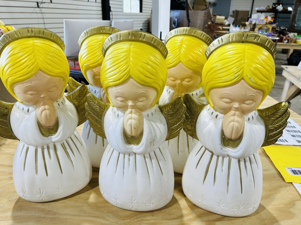 A Collection of Vintage Praying Angel Holiday Blow Mold Figurines: A collection of blow-molded plastic holiday figurines depicting angels in a kneeling and praying pose. These items are attributed to Grand Venture and date to the late 1990s. Each figurine is construc