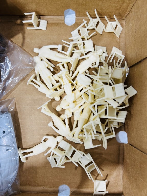A Collection of Vintage Molded Plastic Spectator Figures and Western Model Accessories: This lot consists of an assortment of vintage unpainted plastic accessories and figures, characteristic of components used for mid-20th-century slot car racing sets or model railroad scenery. The item