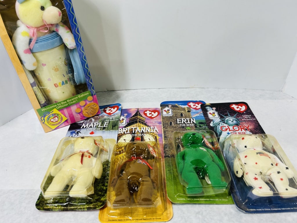A Collection of Five Ty Beanie Babies Including Official Club Kit and McDonald's International Bears: This collection of Ty Inc. items consists of five pieces in original retail packaging. Included is a Welcome to the Beanie Babies Official Club kit and a complete set of four 1999 Ronald McDonald Hous