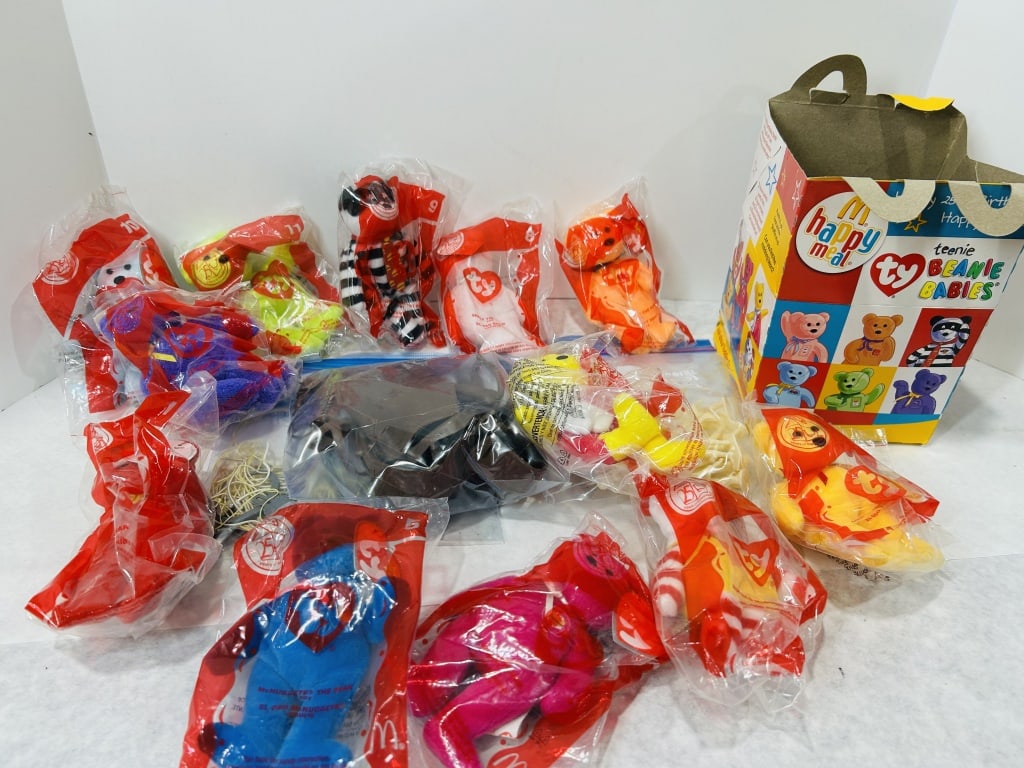 A Collection of Ty Teenie Beanie Babies McDonald's 25th Anniversary Happy Meal Toys and Box: This lot comprises a collection of Ty Teenie Beanie Babies produced in partnership with McDonald's for the 25th anniversary of the Happy Meal in 2004. The plush bean bag toys are primarily housed in t