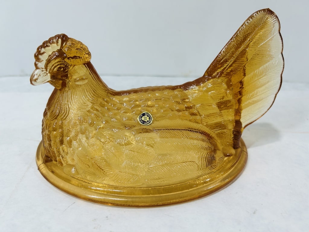 Westmoreland Glass Amber Pressed Glass Hen on Nest Lid: A pressed glass decorative lid in the form of a nesting hen produced by the Westmoreland Glass Company of Grapeville, Pennsylvania. The piece is crafted from translucent amber-colored glass and featur