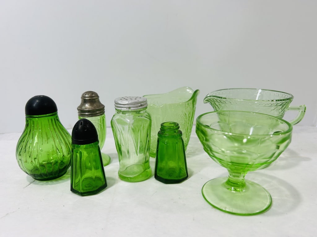 An Assortment of Eight Pieces of Depression-Era Green Glassware including Uranium Glass: This collection consists of several items of American pressed glassware from the mid-20th century, presented in a variety of green tones. Five of the pieces exhibit a bright green fluorescence under u