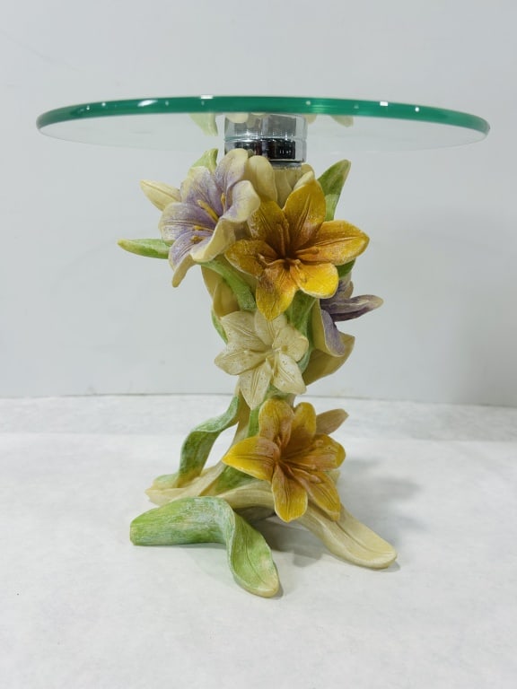 Decorative Lily Motif Resin Display Stand with Round Glass Top: This is a contemporary decorative display stand or riser featuring a sculptural base and a clear glass top. The base is constructed from molded and hand-painted resin, sculpted in the form of a cluste